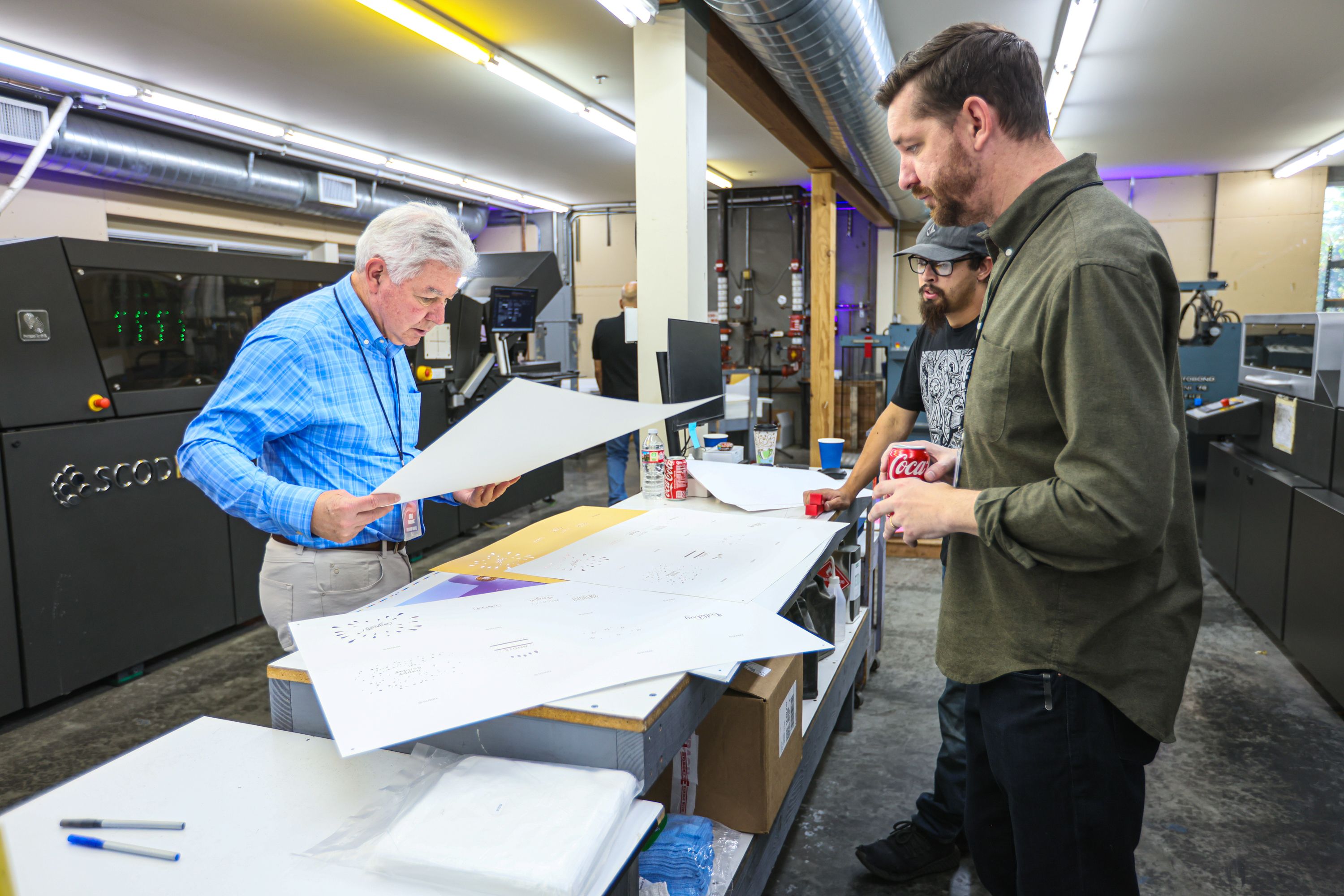 PFI production team reviewing printed sheets