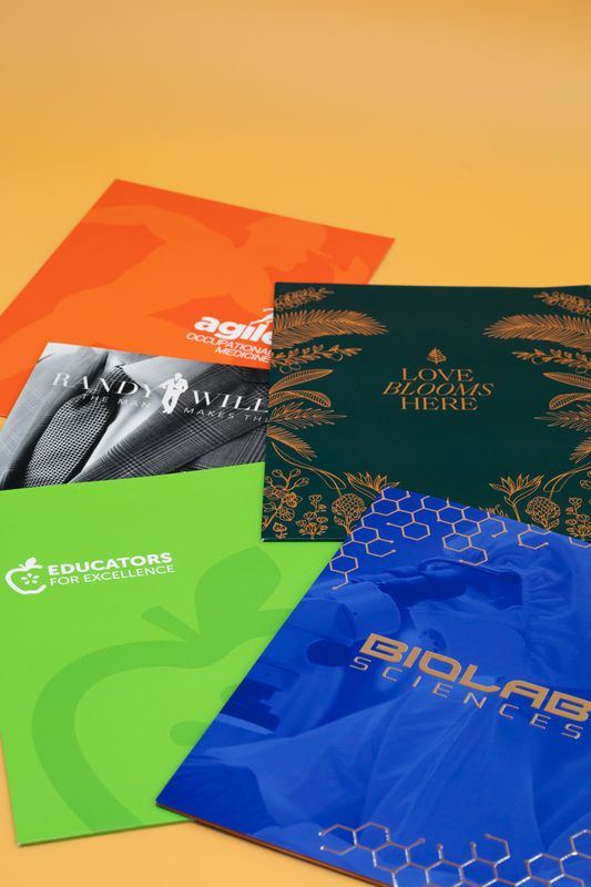 Assortment of printed presentation folders in multiple colors